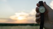 Hand holding a watch up to the horizon