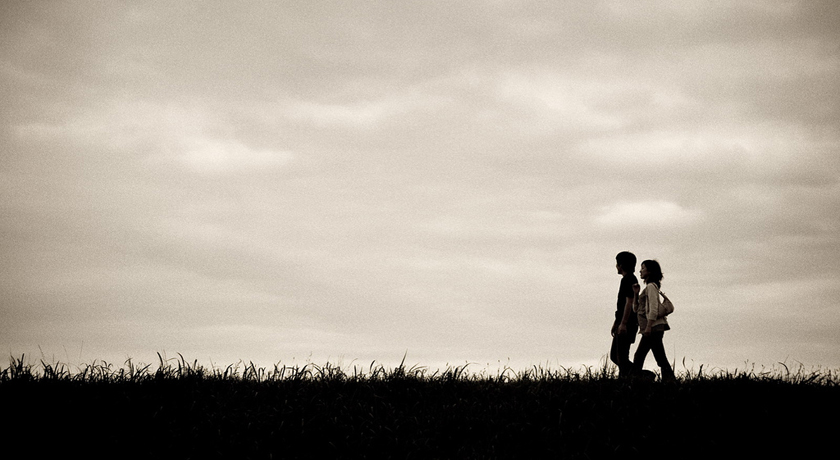 couple walking under grey sky