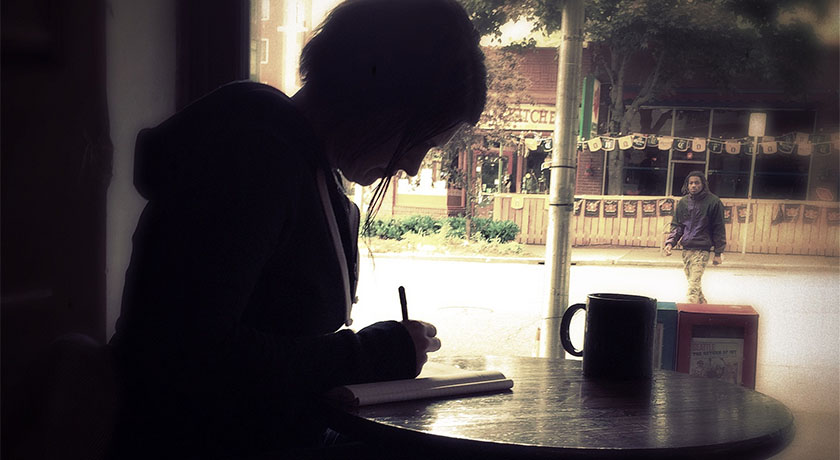 Woman journaling in a cafe