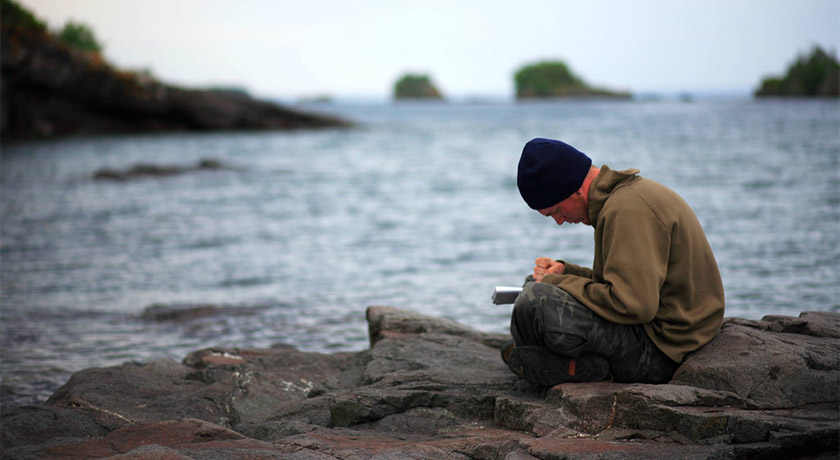 Man journalling by the sea