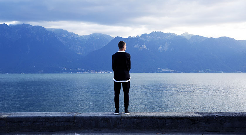 Man standing at edge of a lake