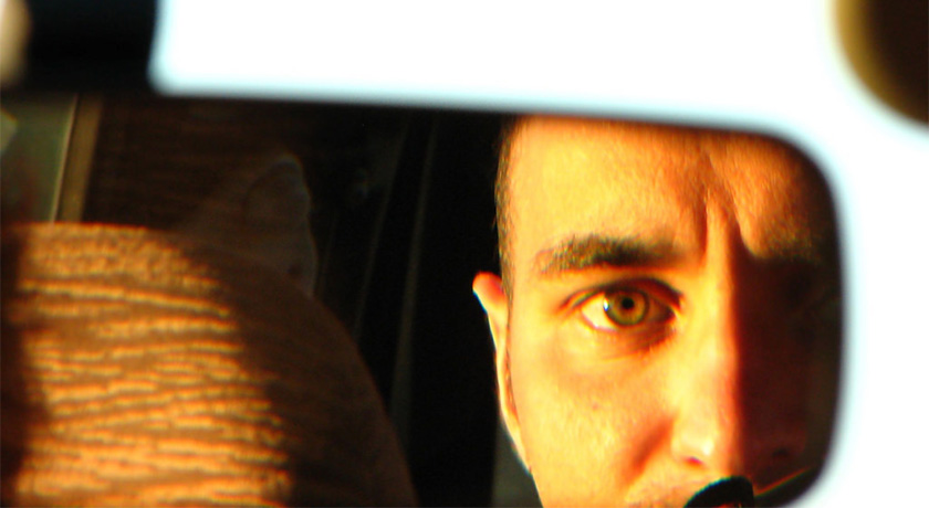 Man looking in rear view mirror