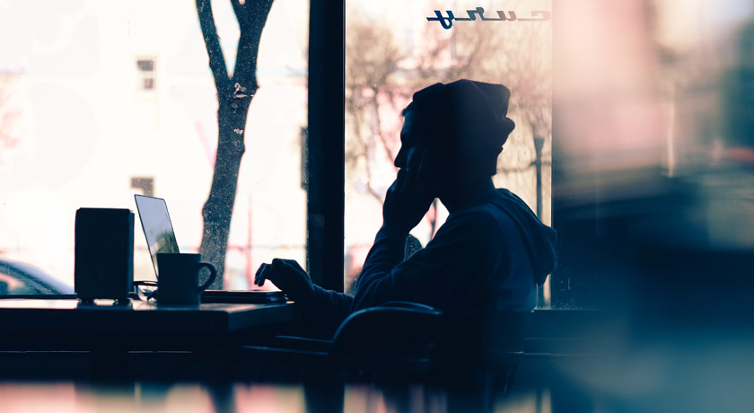 Man in cafe searching for meaning on laptop