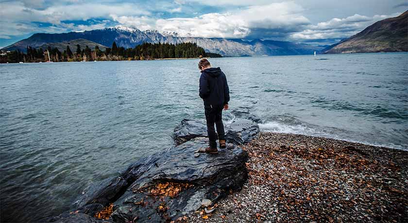 Man at a shoreline looking at the water