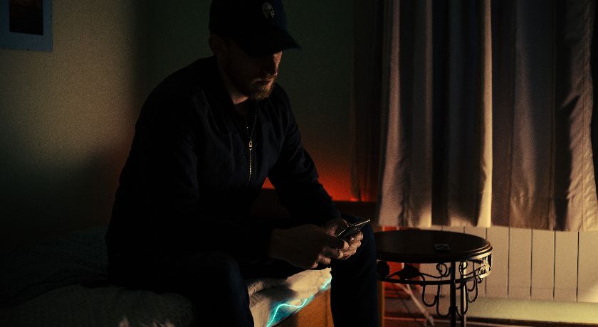 Man using phone in darkened bedroom